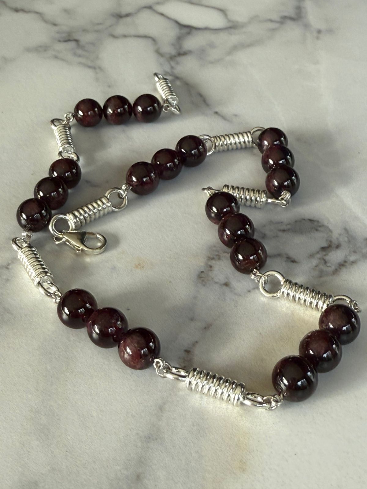 Collar de resortes con granates en plata rodinada de 950