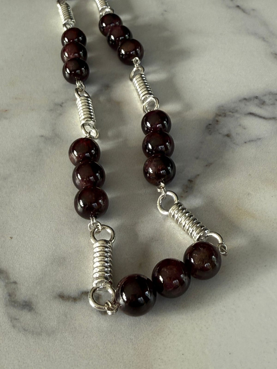 Collar de resortes con granates en plata rodinada de 950
