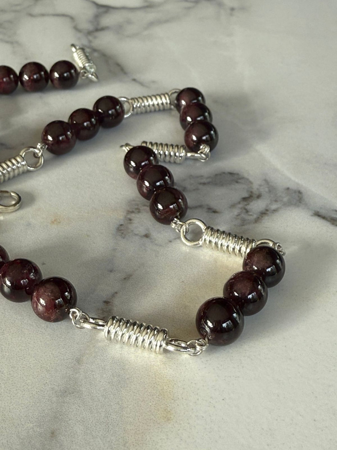 Collar de resortes con granates en plata rodinada de 950